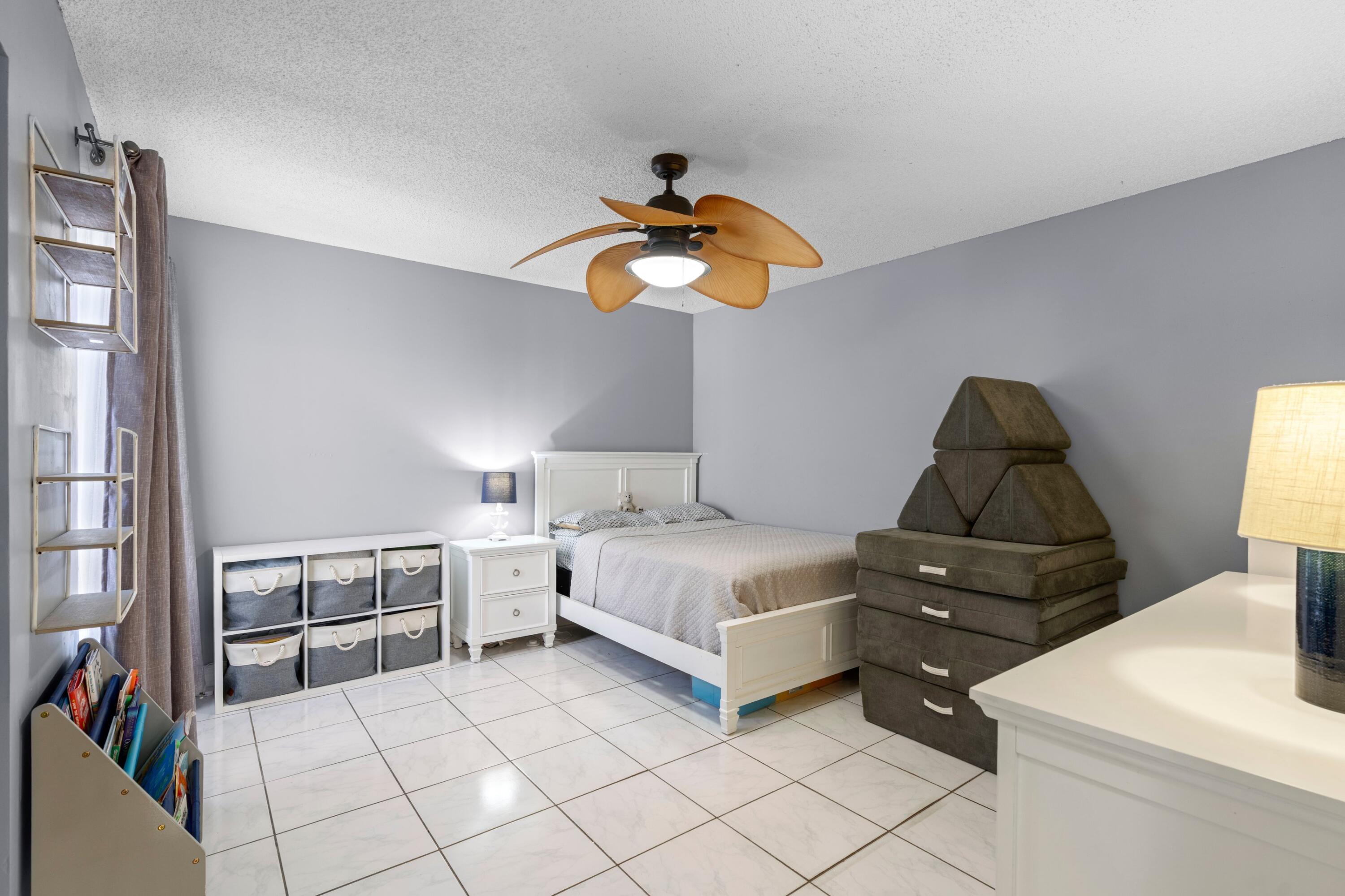 8584 Shawe Way Boca Raton, FL 33433 - Photo 16 of 43 a bedroom with a bed and a chandelier