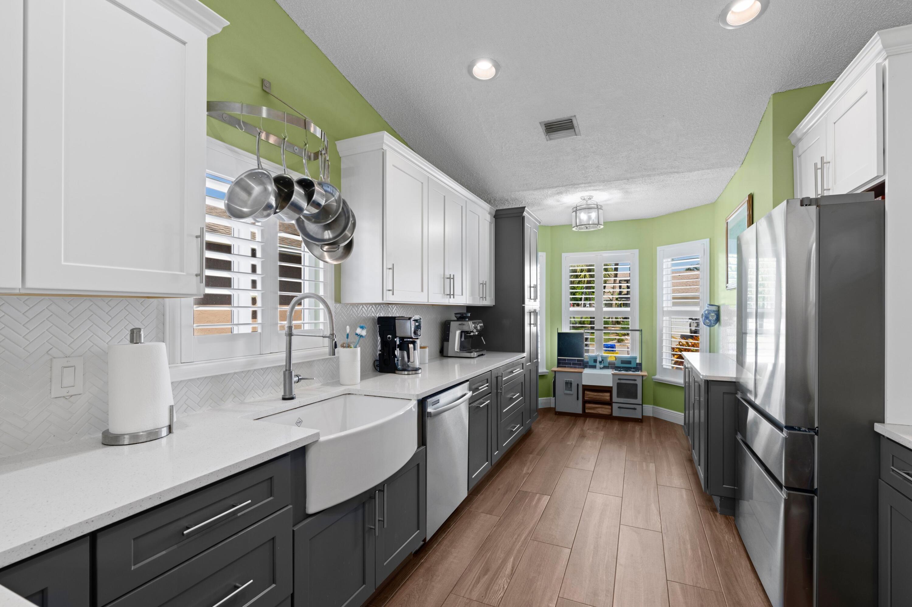8584 Shawe Way Boca Raton, FL 33433 - Photo 8 of 43 a kitchen with stainless steel appliances a sink cabinets and wooden floor