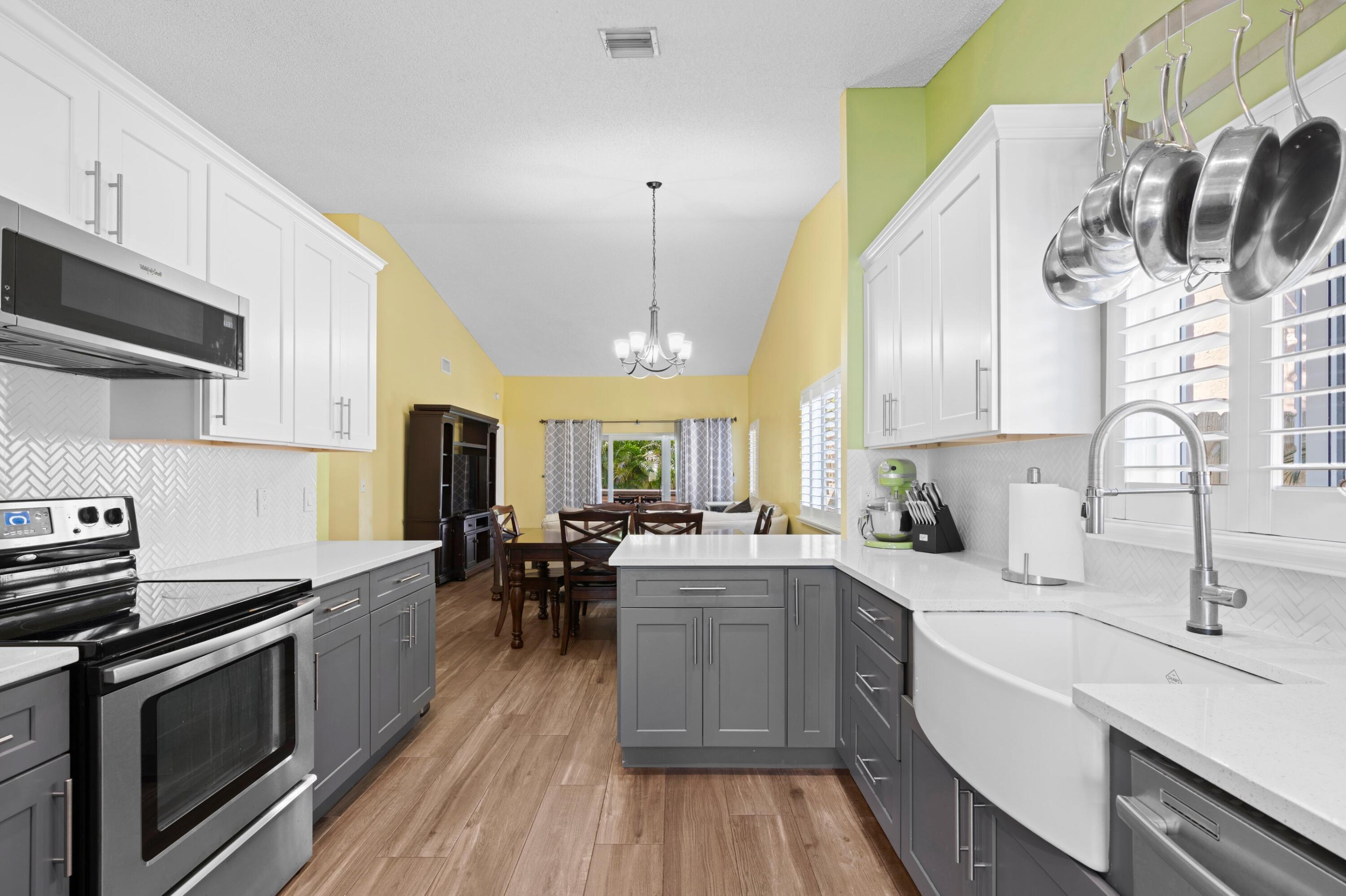 8584 Shawe Way Boca Raton, FL 33433 - Photo 10 of 43 a kitchen with a sink a stove and cabinets