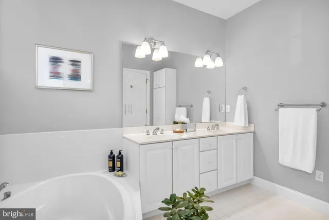a bathroom with a sink a large mirror and a bathtub