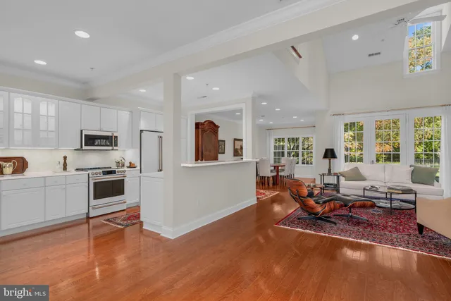 a living room with furniture wooden floor and kitchen view