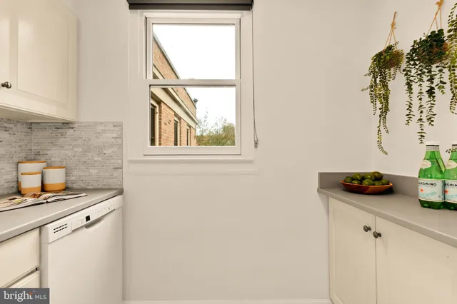 a kitchen with a sink and a stove with wooden floor