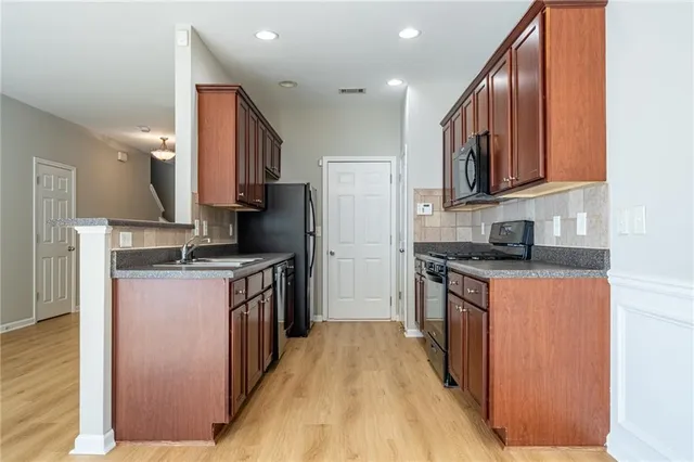 a kitchen with stainless steel appliances granite countertop a stove a sink and a refrigerator