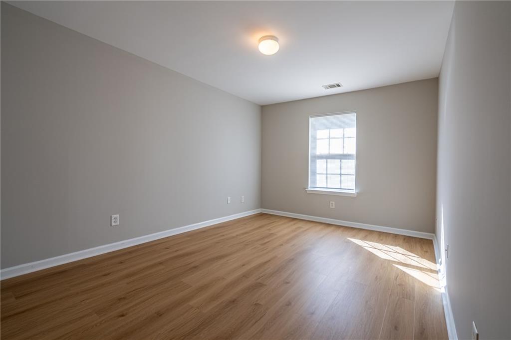 2245 Leicester Way Southeast Atlanta, GA 30316 - Photo 16 of 29 a view of an empty room with wooden floor and a window