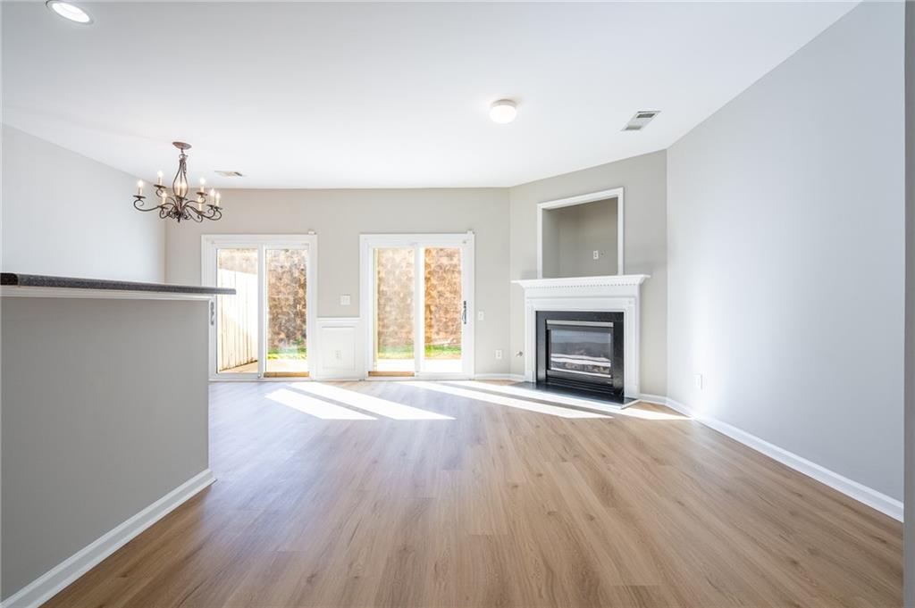 2245 Leicester Way Southeast Atlanta, GA 30316 - Photo 6 of 29 an empty room with wooden floor fireplace and windows