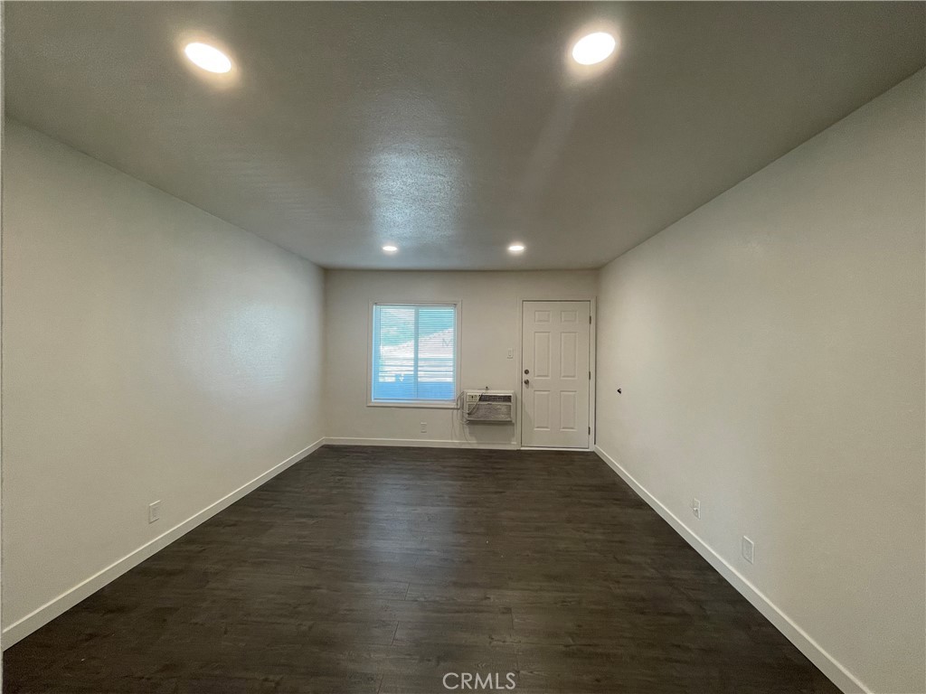 1349 North Altadena Drive, Unit B Pasadena, CA 91107 - Photo 3 of 8 an empty room with wooden floor and windows