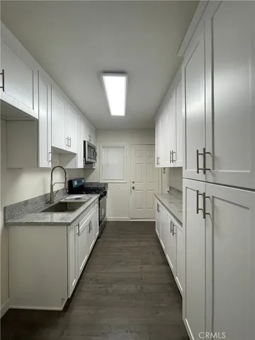 a kitchen with stainless steel appliances granite countertop a sink a stove and a refrigerator