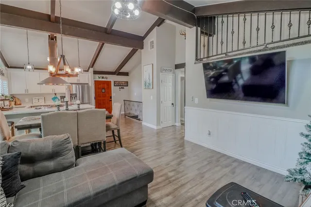 a living room with furniture a clock and a flat screen tv