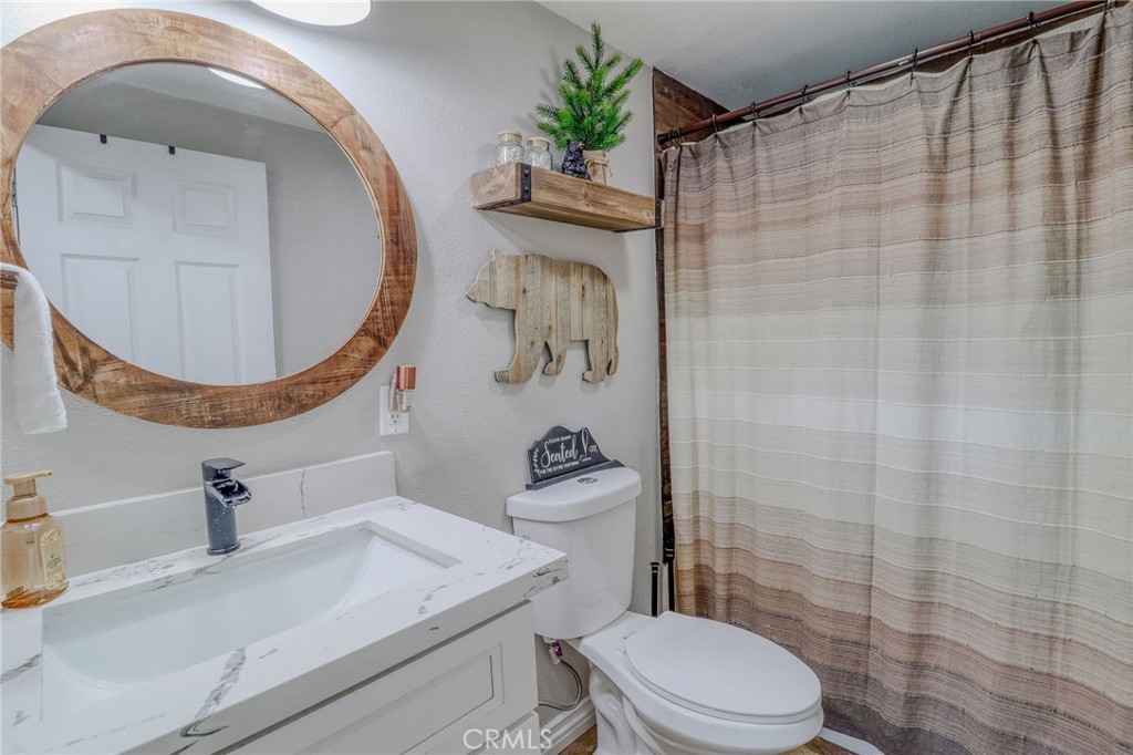 26669 Highway 189 Twin Peaks, CA 92391 - Photo 27 of 68 a bathroom with a sink a toilet and a mirror