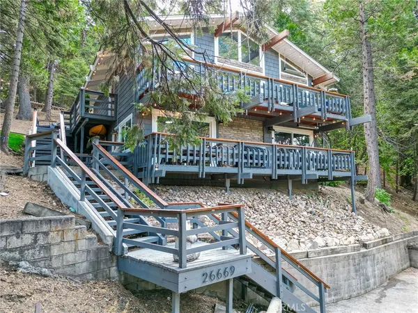 a balcony with tall trees and a wooden floor