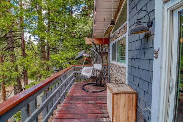 a view of a deck with a big yard potted plants and large tree