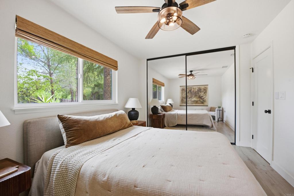 1878 Rancho Jorie Alpine, CA 91901 - Photo 17 of 70 a bedroom with a large bed and a chandelier fan