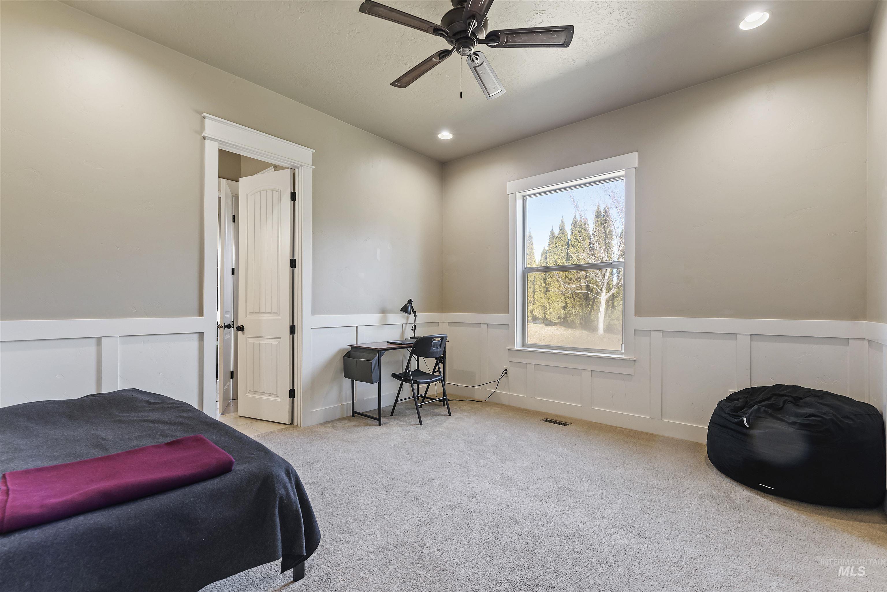 24710 Blessinger Road Star, ID 83669 - Photo 17 of 46 Bedroom with wainscoting, a decorative wall, light carpet, a ceiling fan, and recessed lighting