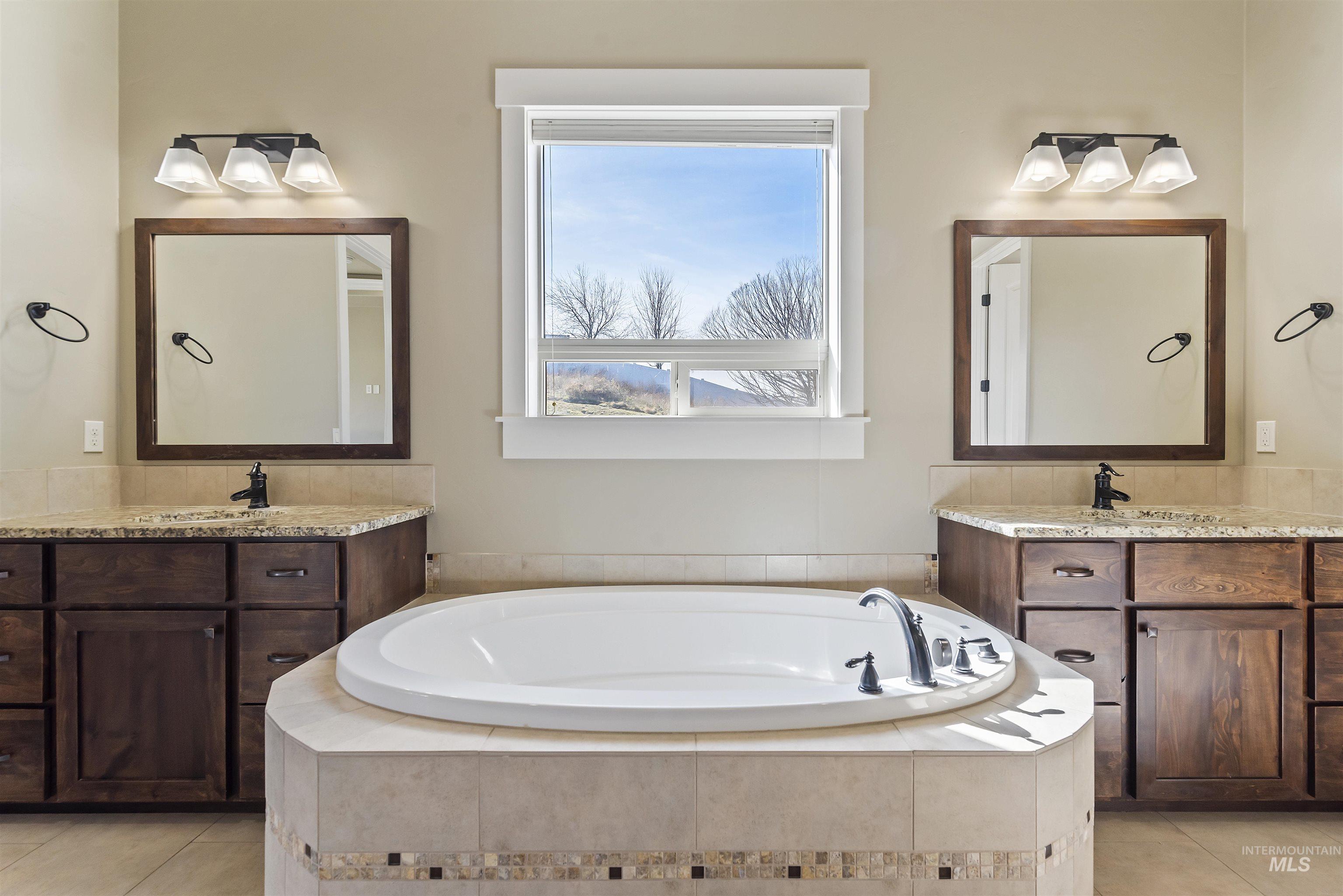 24710 Blessinger Road Star, ID 83669 - Photo 21 of 46 Full bathroom featuring two vanities, light tile patterned flooring, and a bath