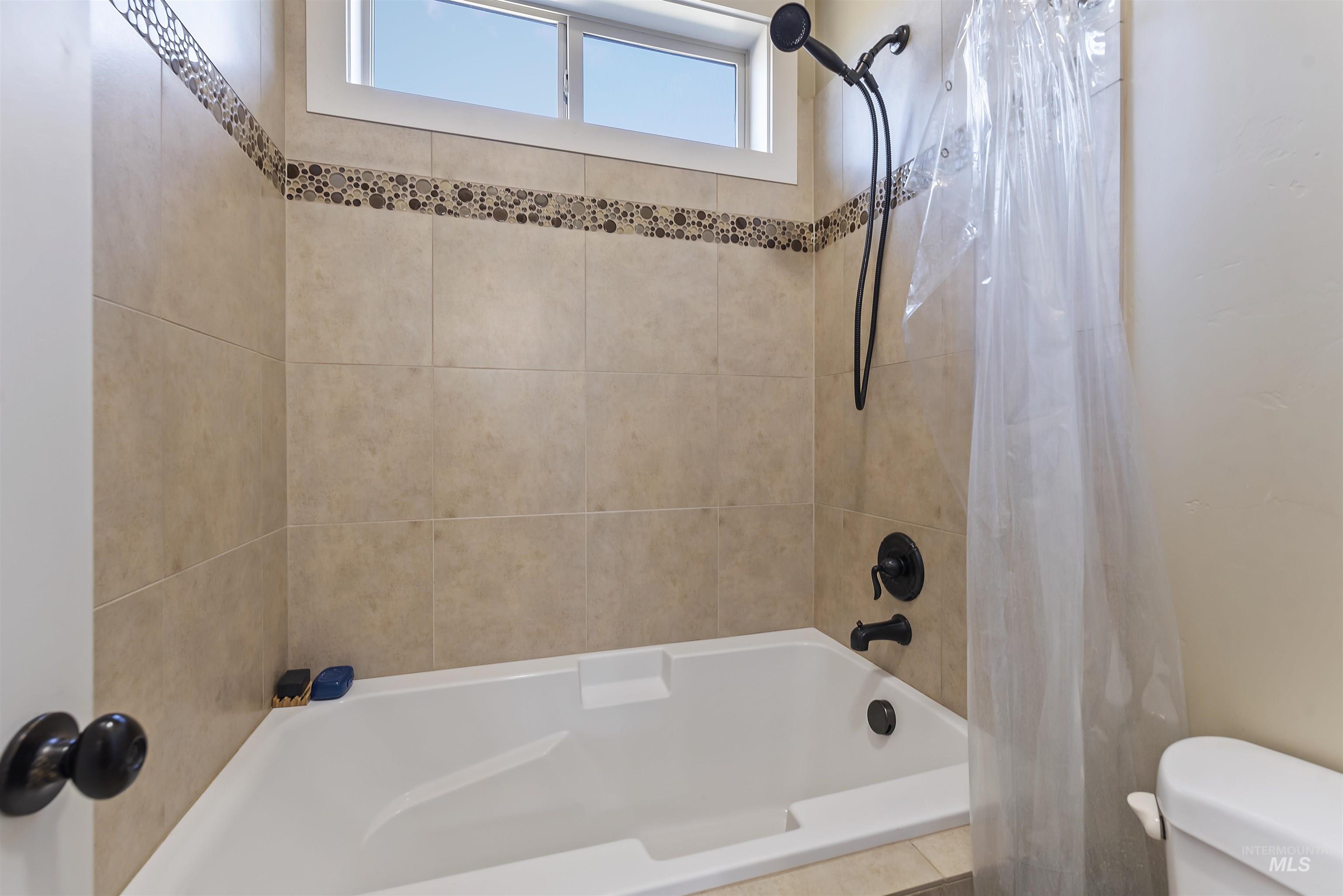 24710 Blessinger Road Star, ID 83669 - Photo 23 of 46 Bathroom with toilet and shower / bath combination with curtain