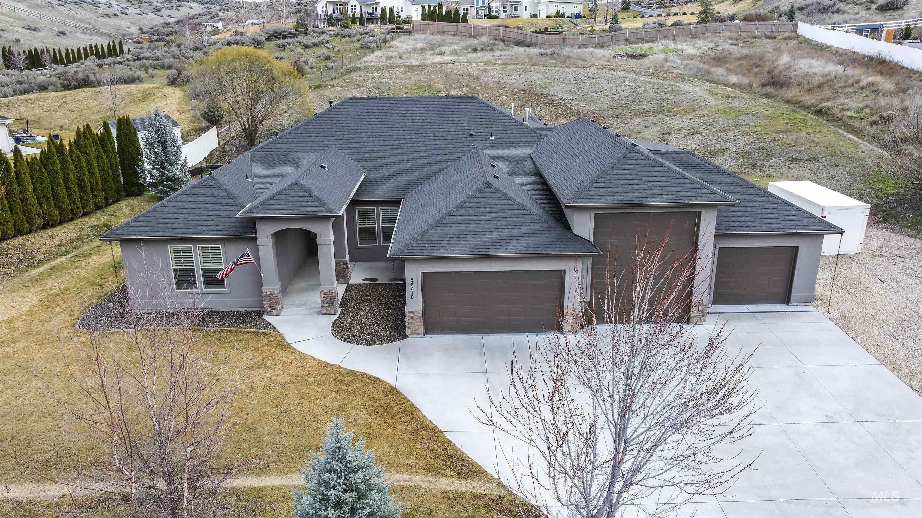 24710 Blessinger Road Star, ID 83669 - Photo 37 of 46 View of front facade with an attached garage, stucco siding, roof with shingles, stone siding, and driveway