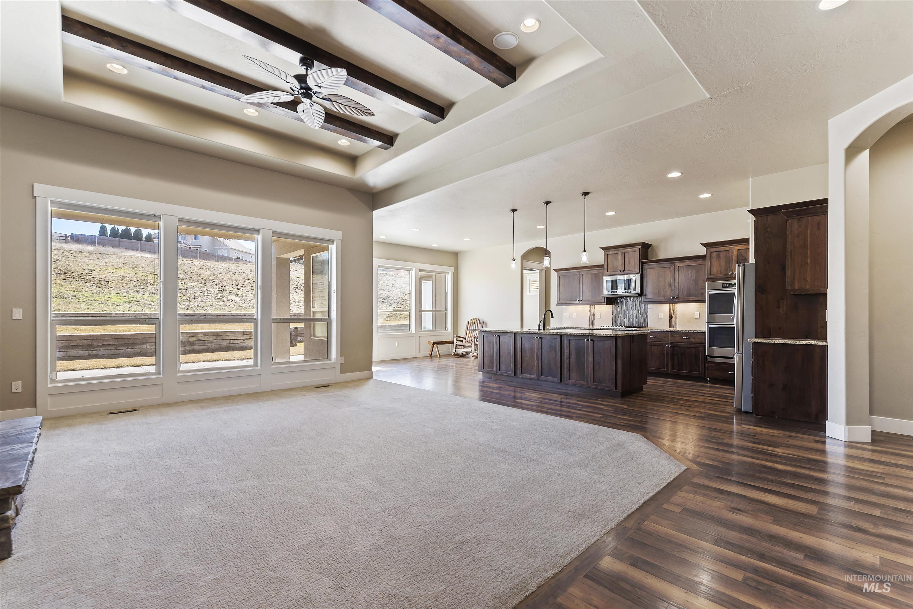 24710 Blessinger Road Star, ID 83669 - Photo 8 of 46 Living area with a tray ceiling, a ceiling fan, recessed lighting, dark wood-style flooring, and arched walkways