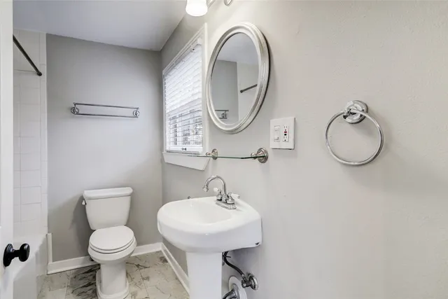 a bathroom with a toilet a sink and a mirror