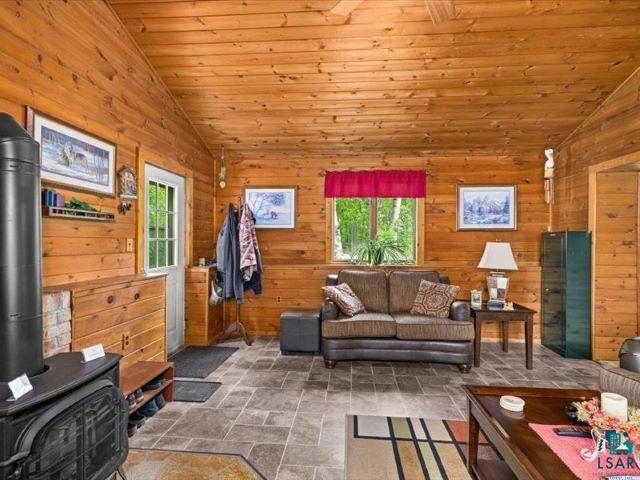3616 Lavaque Road Hermantown, MN 55811 - Photo 39 of 43 Wood-paneled interior featuring a wood-burning stove with a stone surround