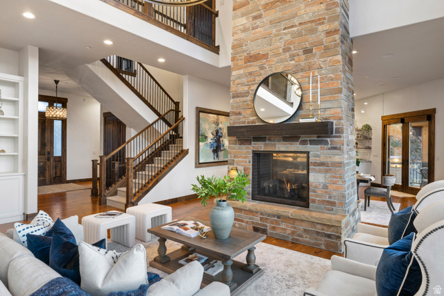 707 Chimney Rock Road, Unit 247 Heber City, UT 84032 - Photo 7 of 64 Living room with wood finished floors, a brick fireplace, recessed lighting, a towering ceiling, and french doors