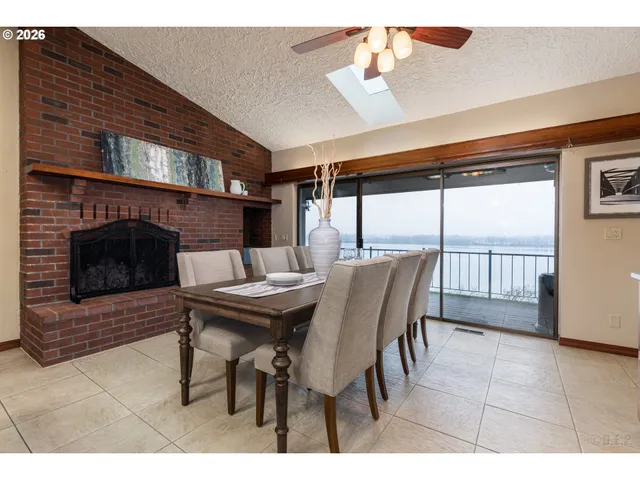 a dining room with furniture a fireplace and wooden floor
