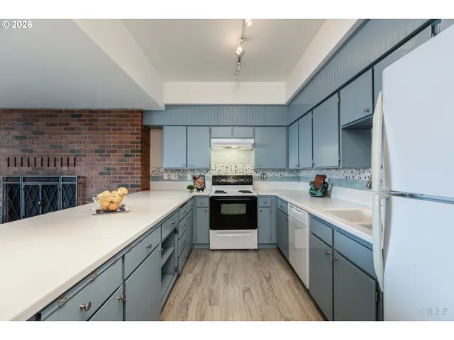 a kitchen with a sink dishwasher a stove top oven a refrigerator and cabinets