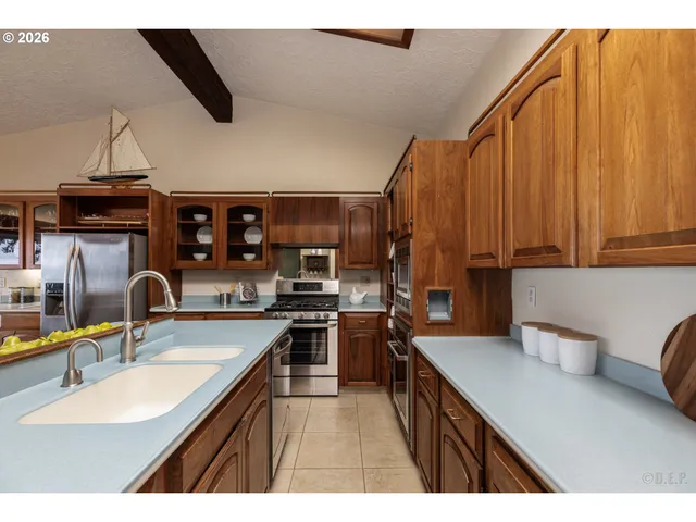 a kitchen with stainless steel appliances a sink dishwasher stove refrigerator and cabinets