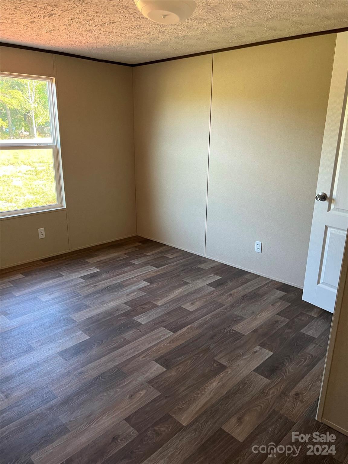 133 Calhoun Road, Unit 2 Stony Point, NC 28678 - Photo 8 of 24 a view of an empty room with wooden floor and a window