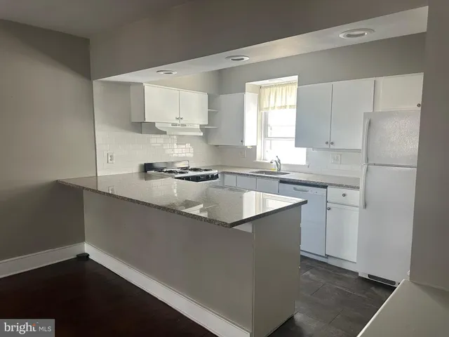 a kitchen with granite countertop a sink cabinets and stainless steel appliances