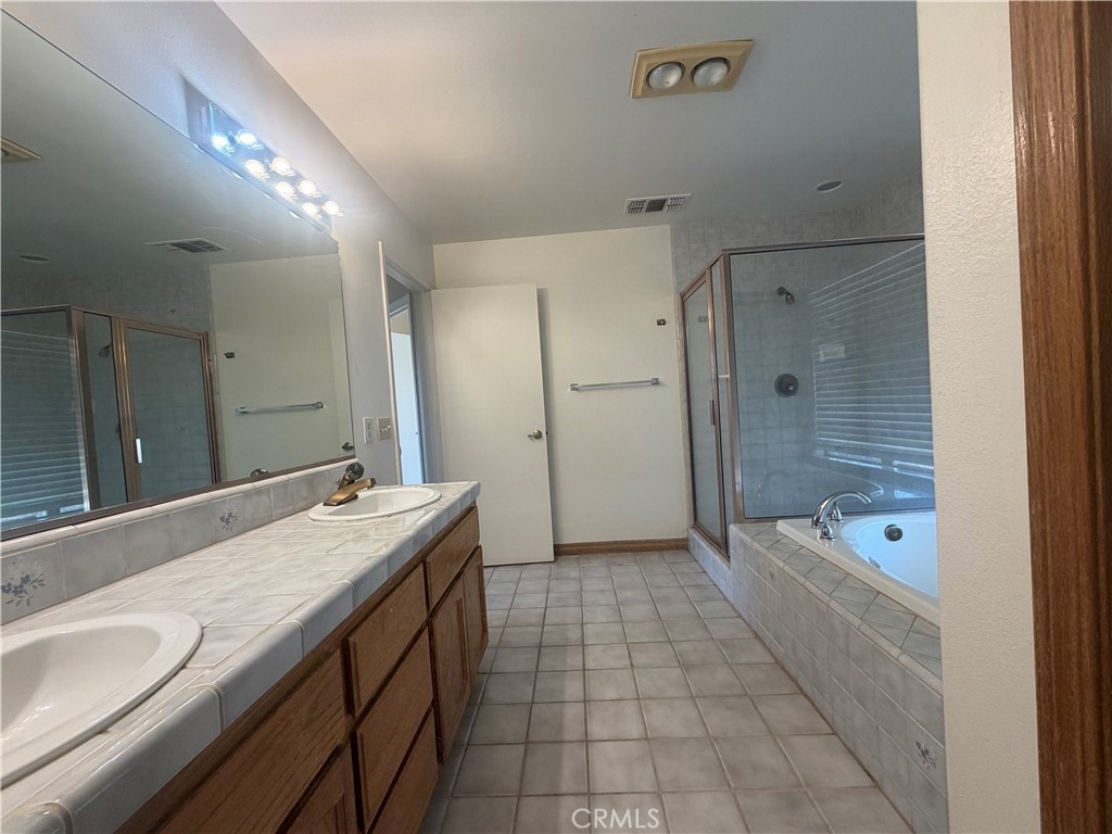 19609 Seneca Road Apple Valley, CA 92307 - Photo 24 of 37 a bathroom with a granite countertop sink a toilet a mirror shower and bathtub