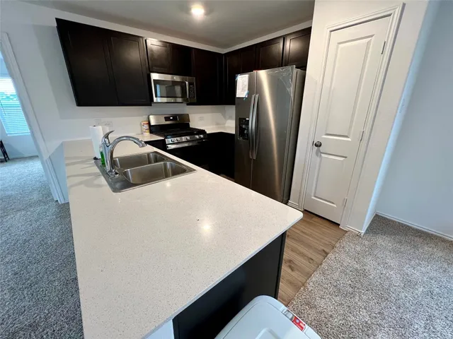 a kitchen with stainless steel appliances a refrigerator sink and microwave