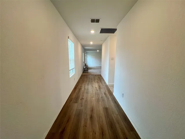 a view of a hallway with wooden floor