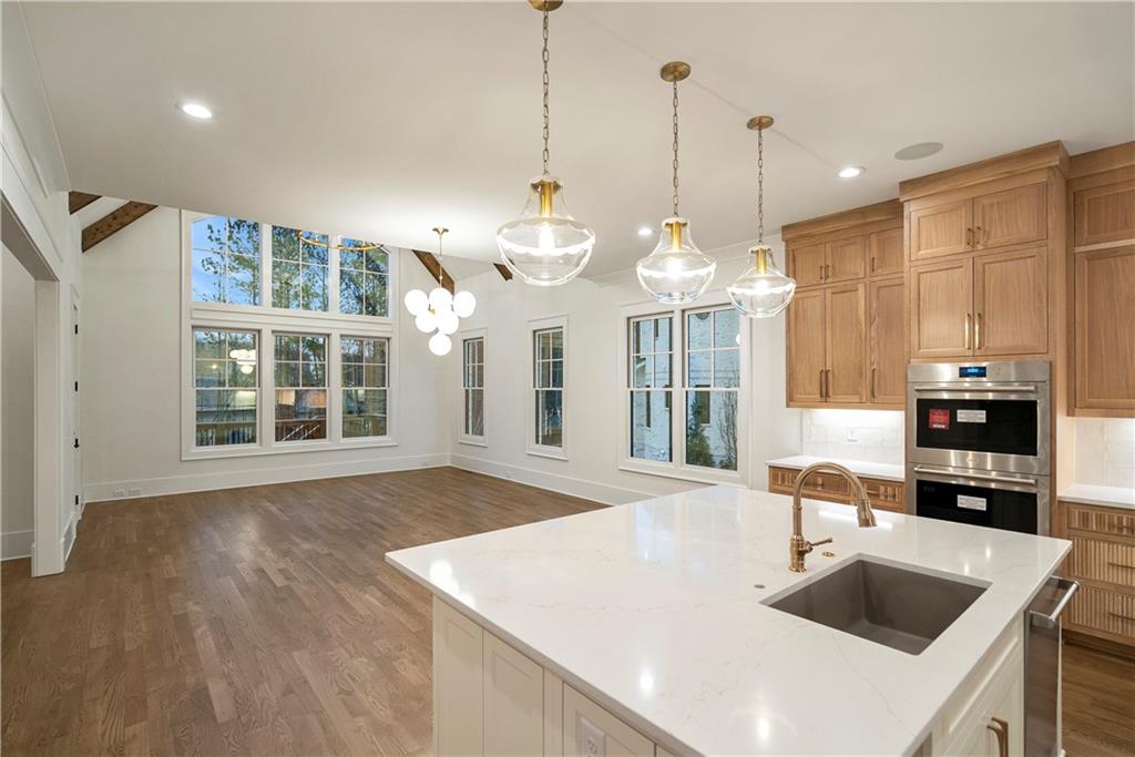 5071 Kings Cl Alpharetta, GA 30004 - Photo 46 of 53 a view of a kitchen island a chandelier and wooden floor