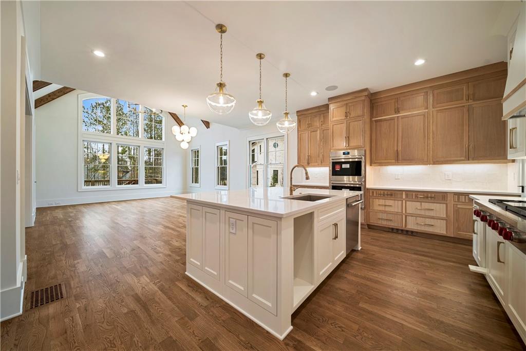 5071 Kings Cl Alpharetta, GA 30004 - Photo 49 of 53 a large kitchen with stainless steel appliances granite countertop a stove and a wooden floors