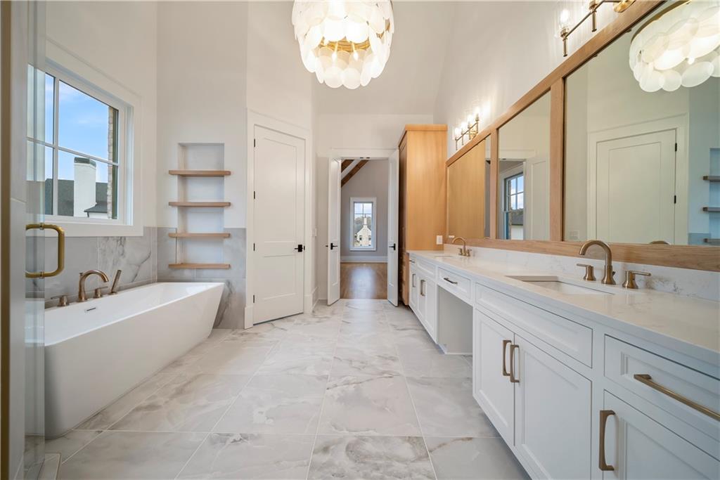 5071 Kings Cl Alpharetta, GA 30004 - Photo 52 of 53 a spacious bathroom with a granite countertop sink mirror and a bathtub