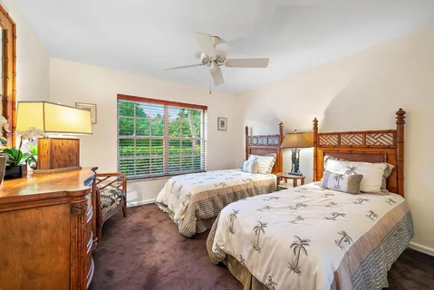 a bed sitting in a bedroom next to a window