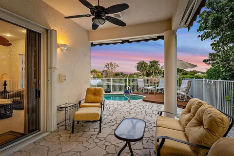 a backyard of a house with sofas table and chairs