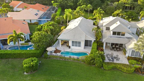 an aerial view of a house with a garden and lake view