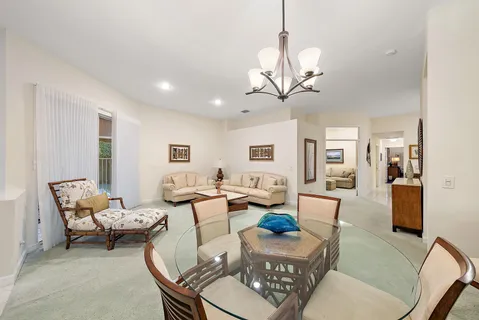 a living room with furniture a chandelier and a dining table