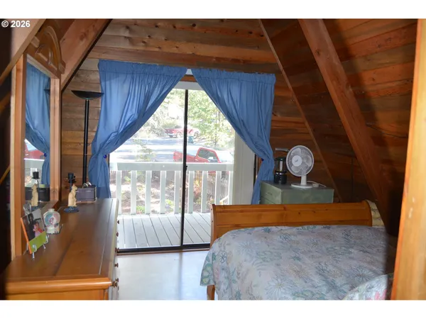 a living room with a bed furniture and a large window