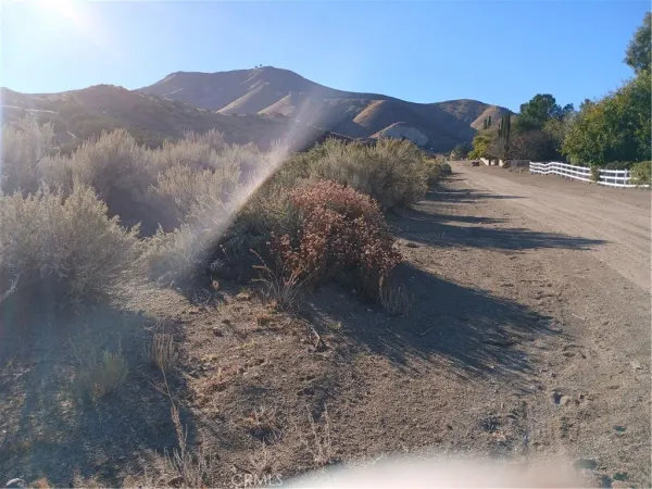a view of a dry yard with mountains in the background