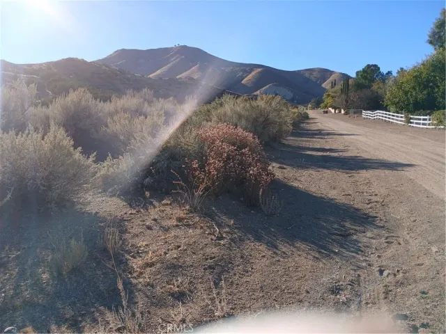 a view of a dry yard with mountains in the background