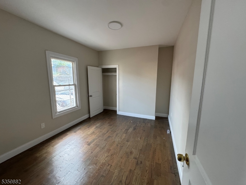 441 Summer Street Paterson, NJ 07501 - Photo 7 of 11 an empty room with wooden floor and windows