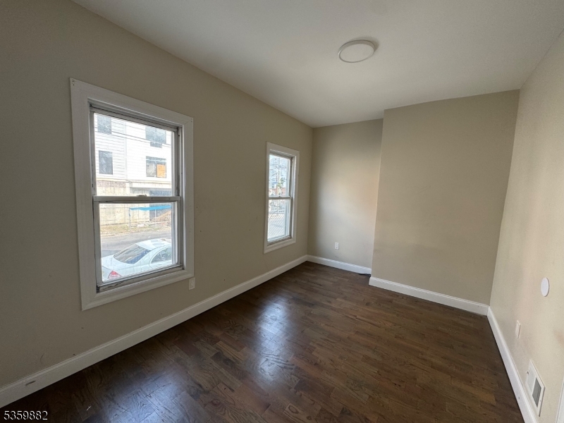 441 Summer Street Paterson, NJ 07501 - Photo 10 of 11 a view of an empty room with wooden floor and a window