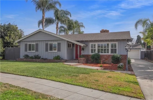 a front view of a house with a yard and potted plants