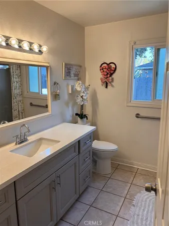 a bathroom with a granite countertop toilet a sink and mirror
