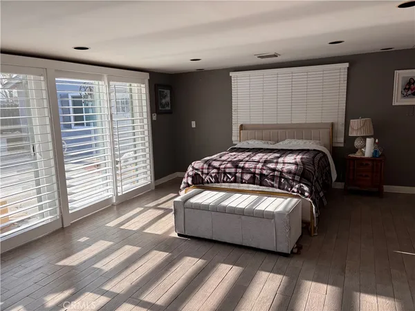 a bedroom with a bed lamp and a large window
