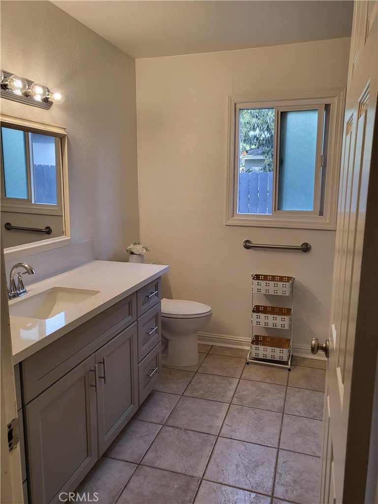 5604 Tower Road Riverside, CA 92506 - Photo 46 of 54 a bathroom with a toilet a sink a mirror and a window