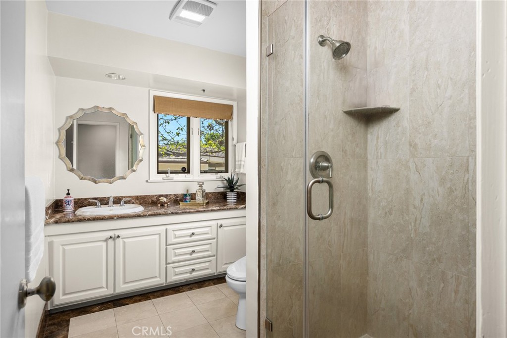 1439 Wembley Road San Marino, CA 91108 - Photo 20 of 45 a bathroom with a granite countertop sink a mirror a vanity and shower