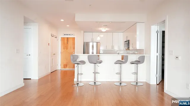 a living room with stainless steel appliances kitchen island furniture and wooden floor